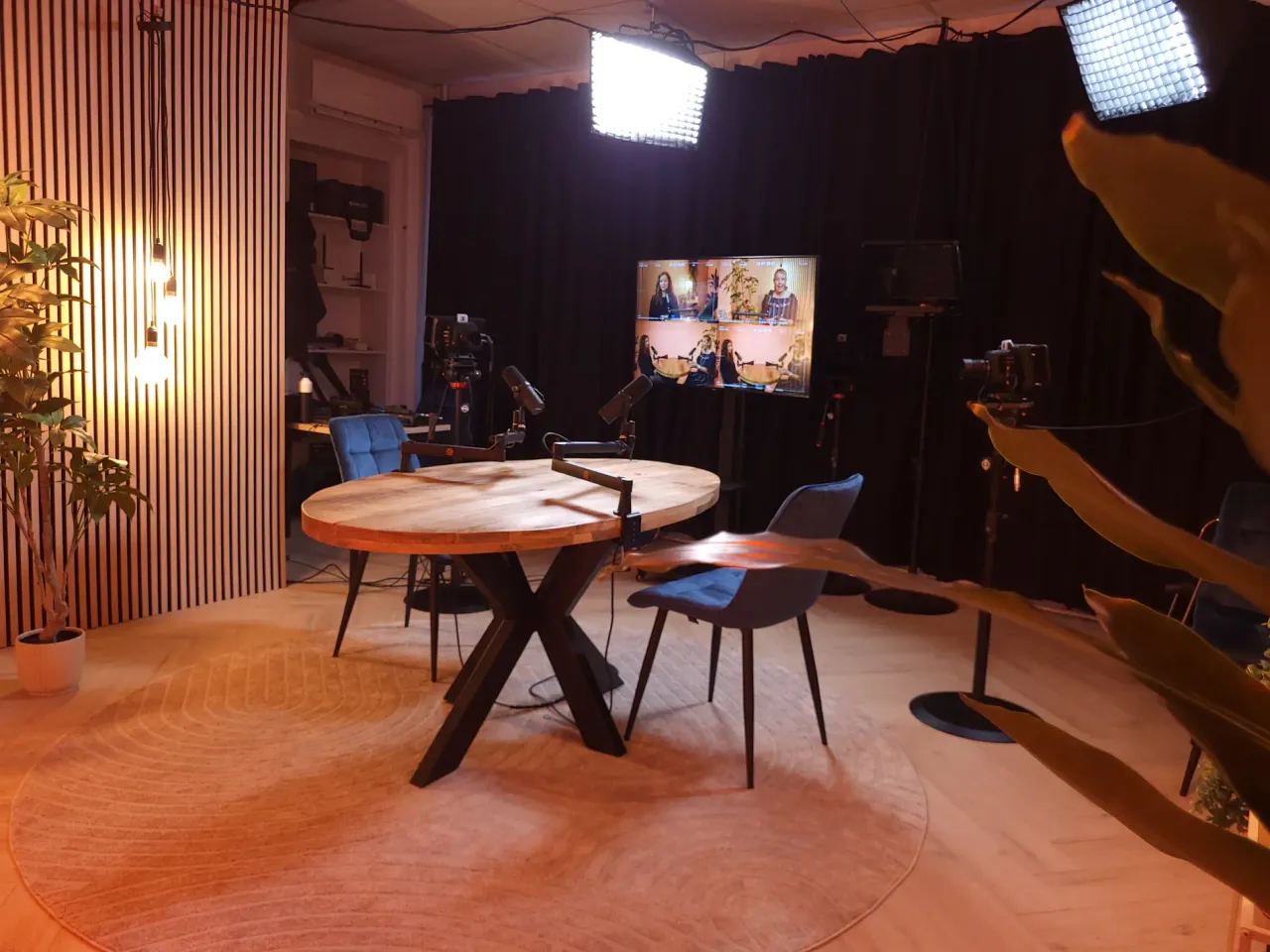 Podcastsetting met tafel, microfoons, camera’s en verlichting in Krommenie